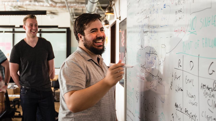 Colleagues writing on a whiteboard