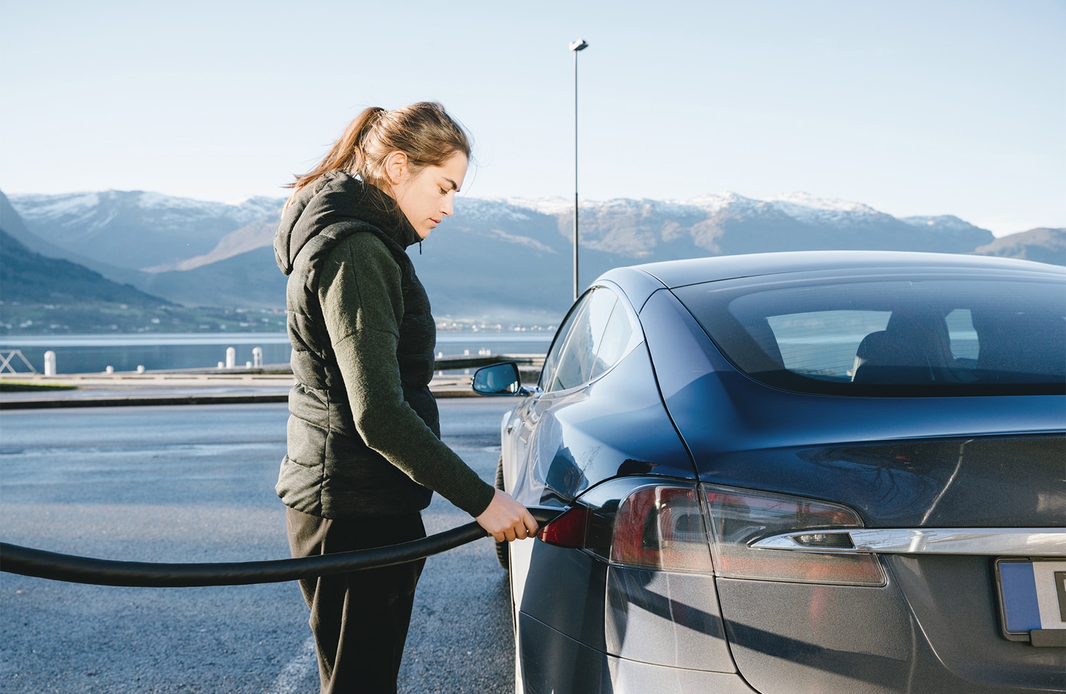 Woman charging electric car