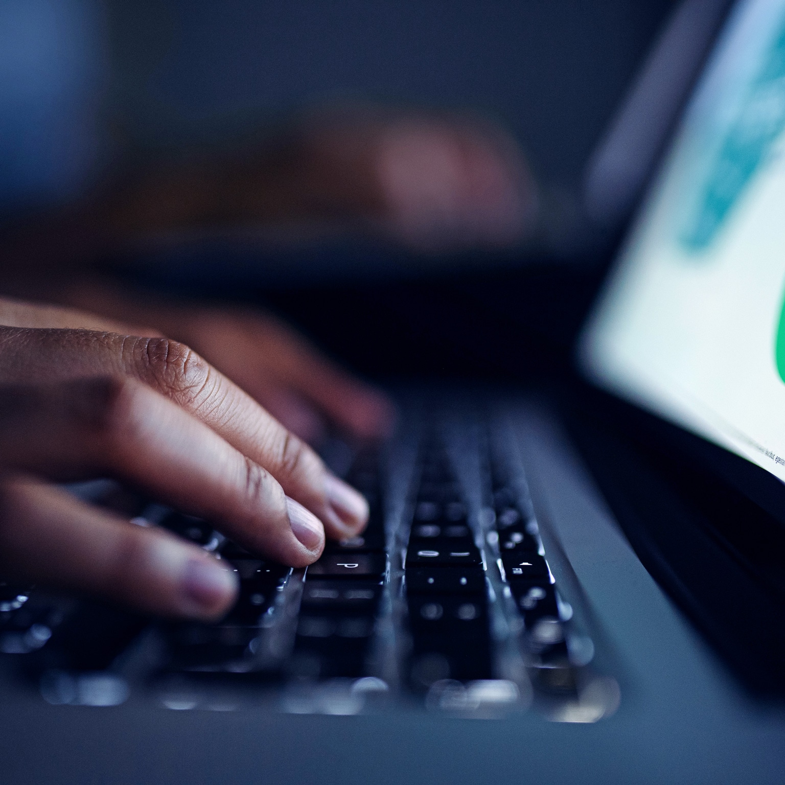 Close-up of female hands working on laptop at home at night